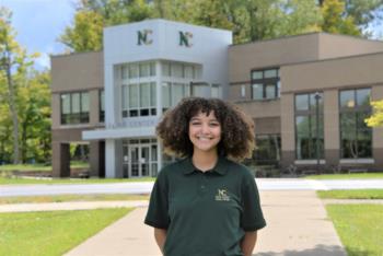 smiling person standing in front of north central state college building