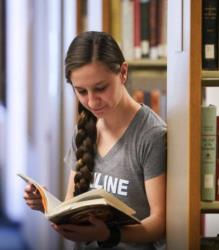 student reading a book in the library