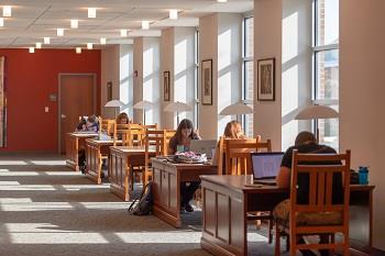 people studying in well-lit university library