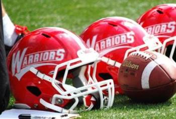 red helmets with 'warriors' on field beside football
