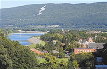 scenic view of a town with hills and water