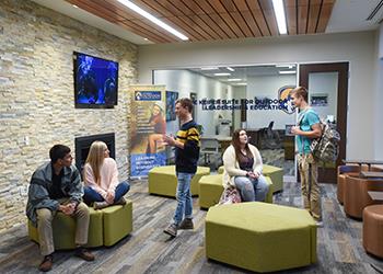 students conversing in a modern campus lounge with posters