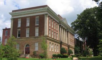 classical brick building with columns and green lawn