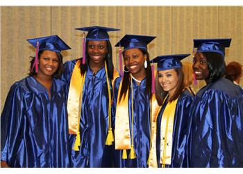 group of graduates smiling in caps and gowns