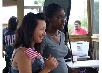 two women standing at an outdoor event