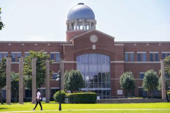 brick building with central clock tower and glass windows