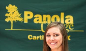 woman smiling with 'Panola' sign behind her
