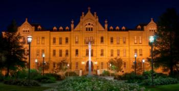 historic campus building lit up at dusk