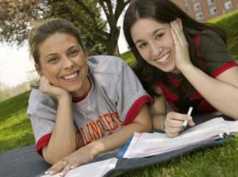 two students studying on the grass