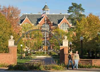 archway entrance to campus with walking couple