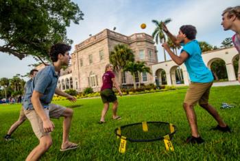 students playing spikeball on campus lawn
