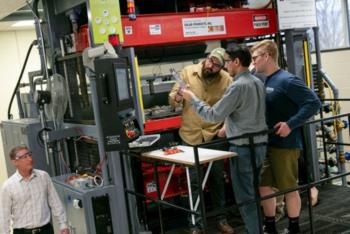 three people discussing in front of machinery