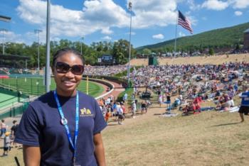 smiling individual in yellow at sports event