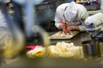 chef decorating pastries in kitchen