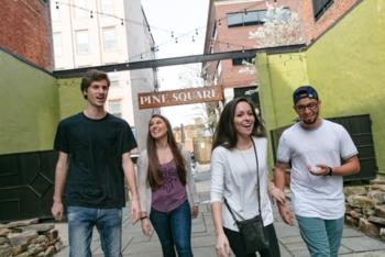four individuals walking in urban alley