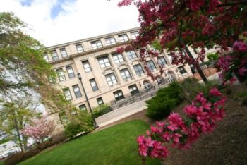 campus building with flowering trees in foreground