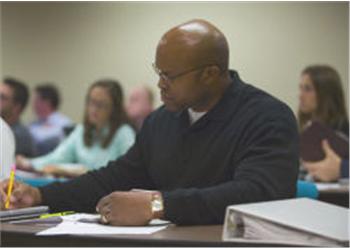 man taking notes during a lecture