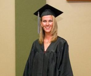 woman in graduation attire smiling