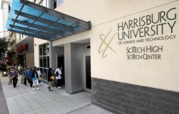 students walking by 'harrisburg university' entrance