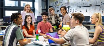 students collaborating in a classroom with computers