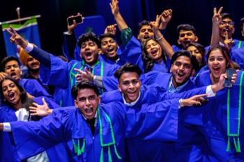 students in blue gowns celebrating at convocation